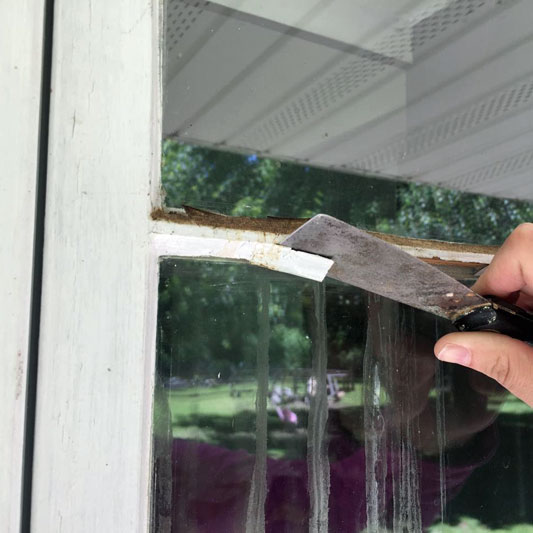 Stripping caulk on a window for reglazing