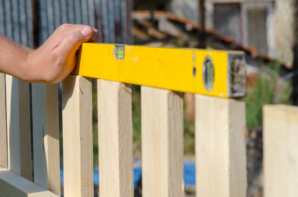 Professional handyman repairing and installing a backyard fence in Kansas City